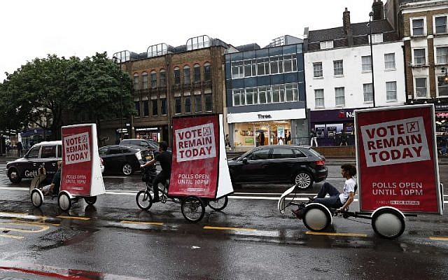 People cycle with "Vote Remain" billboards urging people to vote in north London on June 23, 2016, as Britain holds a referendum on whether to remain in, or to leave the European Union (EU). (AFP PHOTO / ODD ANDERSEN)