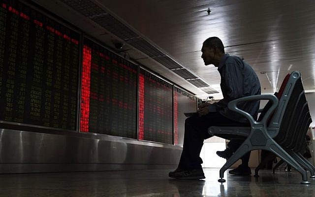 An investor watches stock price movements on a screen at a securities company in Beijing on June 24, 2016. (AFP PHOTO / GREG BAKER) An investor watches stock price movements on a screen at a securities company in Beijing on June 24, 2016. (AFP PHOTO / GREG BAKER)