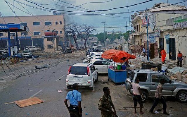 People and Somali security forces walk across the scene of a car bomb attack claimed by Al-Qaeda-affiliated Shabab militants which killed at least 5 people, on the Naasa Hablood hotel in Mogadishu on June 25, 2016. (AFP PHOTO / MOHAMED ABDIWAHAB) People and Somali security forces walk across the scene of a car bomb attack claimed by Al-Qaeda-affiliated Shabab militants which killed at least 5 people, on the Naasa Hablood hotel in Mogadishu on June 25, 2016. (AFP PHOTO / MOHAMED ABDIWAHAB)