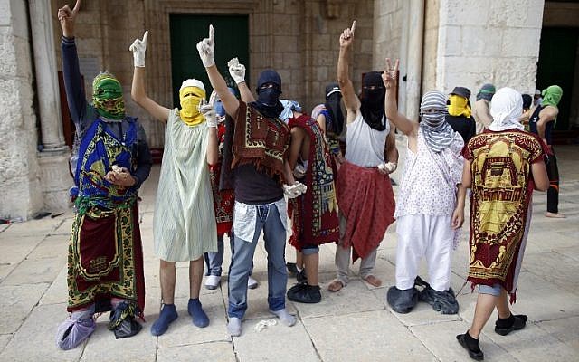Masked Palestinian protesters wearing pieces of cloth around their bodies gesture during clashes with the Israeli police at Jerusalem's Temple Mount compound for the thrid consecutive day on June 28, 2016. (AFP/AHMAD GHARABLI) Masked Palestinian protesters wearing pieces of cloth around their bodies gesture during clashes with the Israeli police at Jerusalem's Temple Mount compound for the thrid consecutive day on June 28, 2016. (AFP/AHMAD GHARABLI)