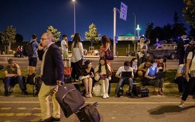 Passengers wait at Ataturk airport`s main entrance in Istanbul, on June 28, 2016, after two explosions followed by gunfire hit Turkey's largest airport, killing at least  36. (AFP / OZAN KOSE)