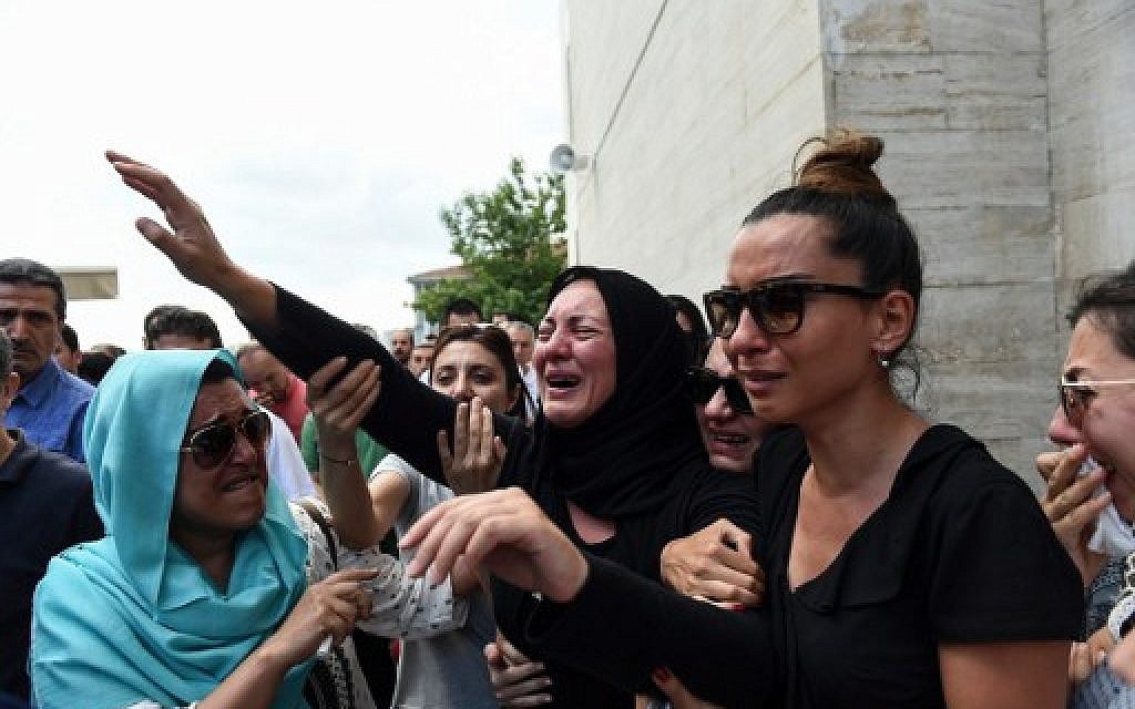 The daughter of Siddik Turgan, who was killed in the June 28, 2016 Istanbul airport attack, reacts as her father's coffin is carried nearby during his funeral ceremony on June 29, 2016. (AFP/BULENT KILIC)