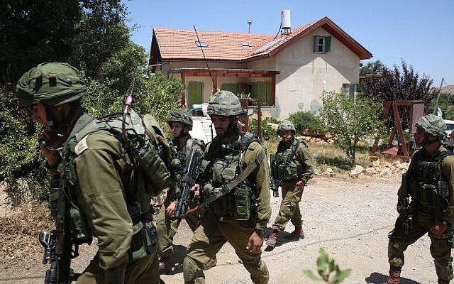 Israeli soldiers stand guard outside a house in the Jewish settlement of Kiryat Arba where a 13-year-old Israeli girl was fatally stabbed in her bedroom on June 30, 2016. (AFP/MENAHEM KAHANA)