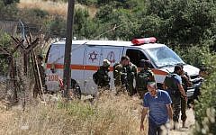 An ambulance and soldiers are seen outside a house in Kiryat Arba where a 13-year-old Israeli girl was stabbed to death in her bedroom by a Palestinian terrorist on June 30, 2016. (AFP/Menahem Kahana)