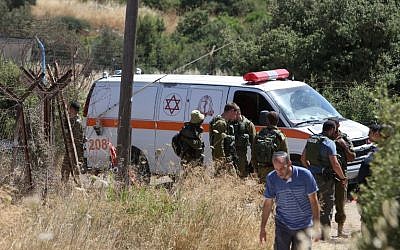 An ambulance and soldiers are seen outside a house in Kiryat Arba where a 13-year-old Israeli girl was stabbed to death in her bedroom by a Palestinian terrorist on June 30, 2016. (AFP PHOTO/MENAHEM KAHANA)