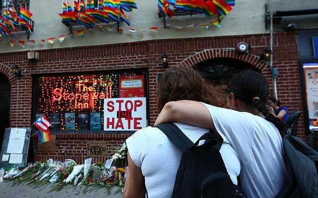 Women embrace before a make-shift memorial in front of the Stonewall Inn in New York City, where a vigil was held following the massacre that occurred at a gay Orlando nightclub on June 12, 2016. Monika Graff/Getty Images/AFP)
