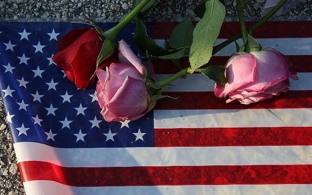 ORLANDO, FL - JUNE 13: Flowers and an American flag are seen on the ground near the Pulse Nightclub where Omar Mateen allegedly killed at least 50 people on June 13, 2016 in Orlando, Florida. The mass shooting killed at least 50 people and injuring 53 others in what is the deadliest mass shooting in the country's history. Joe Raedle/Getty Images/AFP