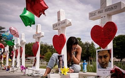 A woman writes a note on a cross at a memorial for each of the 49 victims of the Pulse Nightclub, next to the Orlando Regional Medical Center, June 17, 2016 in Orlando, Florida (Drew Angerer/Getty Images/AFP) A woman writes a note on a cross at a memorial for each of the 49 victims of the Pulse Nightclub, next to the Orlando Regional Medical Center, June 17, 2016 in Orlando, Florida (Drew Angerer/Getty Images/AFP)