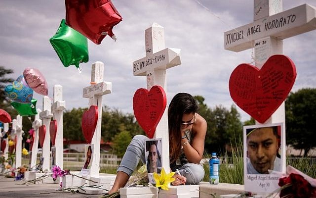 A woman writes a note on a cross at a memorial for each of the 49 victims of the Pulse Nightclub, next to the Orlando Regional Medical Center, June 17, 2016 in Orlando, Florida (Drew Angerer/Getty Images/AFP) A woman writes a note on a cross at a memorial for each of the 49 victims of the Pulse Nightclub, next to the Orlando Regional Medical Center, June 17, 2016 in Orlando, Florida (Drew Angerer/Getty Images/AFP)
