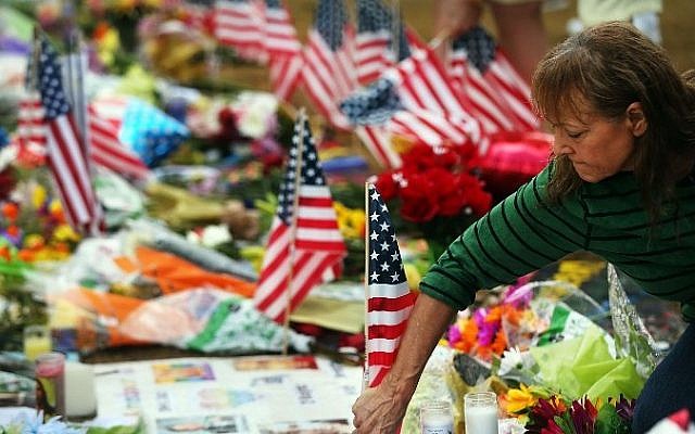 A woman places American flags at a memorial down the road from the Pulse nightclub on June 19, 2016 in Orlando, Florida. Spencer Platt/Getty Images/AFP)