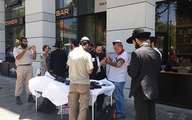 File: Chabad members invite male passersby to don tefillin at the site of the June 8, 2016 terror attack at the Sarona Market in Tel Aviv, June 9, 2016. (Ricky Ben-David) File: Chabad members invite male passersby to don tefillin at the site of the June 8, 2016 terror attack at the Sarona Market in Tel Aviv, June 9, 2016. (Ricky Ben-David)