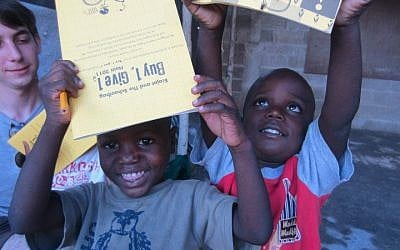 September, 2011 photo of Haitian children enjoying Ecojot notebooks donated by Erin Schrode's nonprofit, The Schoolbag, dedicated to providing children in need with eco-sustainable school supplies (facebook/The Schoolbag)