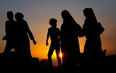 Palestinians walk toward the Qalandia checkpoint between the West Bank city of Ramallah and Jerusalem on their way to pray at the Al-Aqsa Mosque in Jerusalem, during the Muslim holy month of Ramadan, Friday, June 17, 2016. (AP Photo/Majdi Mohammed)