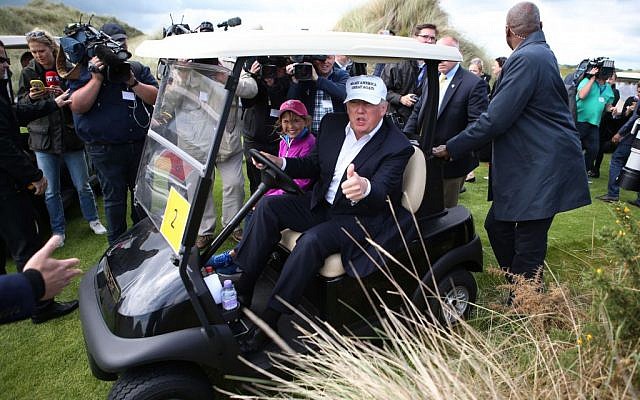 US presidential candidate Donald Trump chats with the watching media aboard a golf cart with granddaughter Kai after he arrived at the Trump International Golf Links at Balmedie, near Aberdeen, Scotland, Saturday June 25, 2016. (Andrew Milligan / PA via AP) 