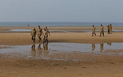 WWII enthusiasts from Spain wearing 101st Airbone gears walk on Omaha beach next to the Colleville American military cemetery, in Colleville sur Mer, western France, June 5, 2016. (AP Photo/Francois Mori)