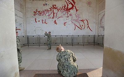 American E6 soldier John, from Virginia Beach, whose grand-father was a pilot in Canadian Air Force during WWII, looks at the map of the memorial in the Colleville American military cemetery, in Colleville sur Mer, western France,  June 5, 2016. (AP Photo/Francois Mori)