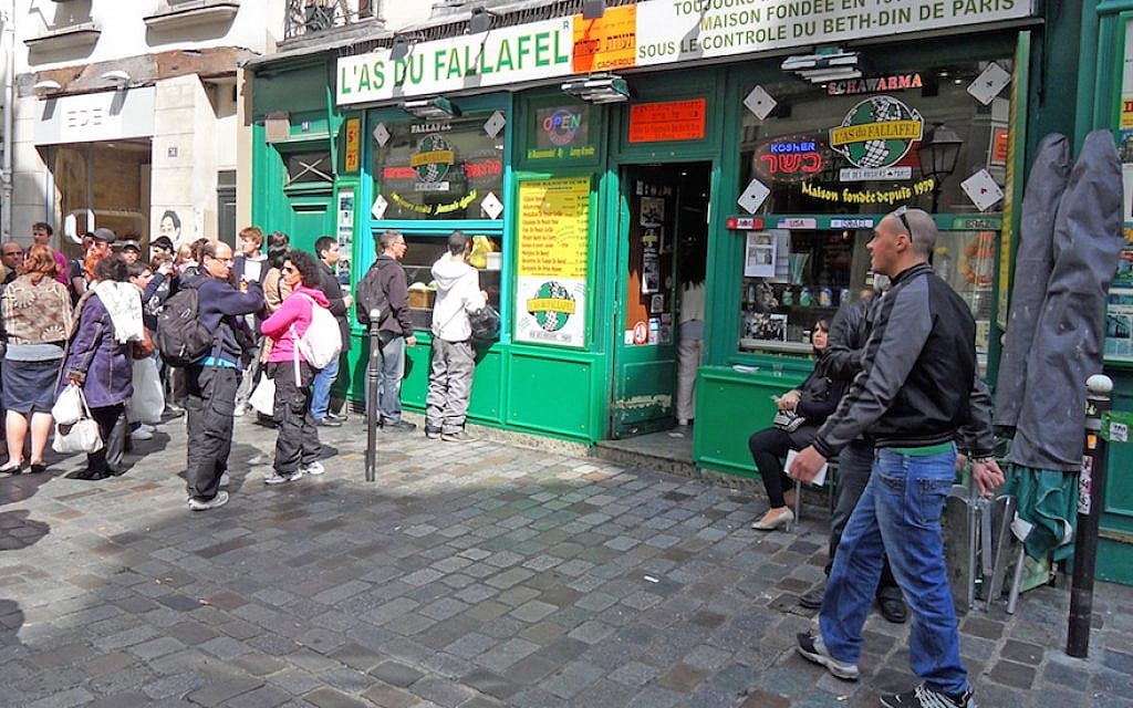 Yomi Peretz, right, approaching a line of tourists waiting to place their orders at The Falafel Ace in the historic Jewish quarter of Paris, April 2012. (WikiMedia Commons) Yomi Peretz, right, approaching a line of tourists waiting to place their orders at The Falafel Ace in the historic Jewish quarter of Paris, April 2012. (WikiMedia Commons)