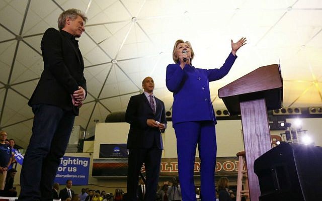 Democratic presidential candidate Hillary Clinton stands on stage with musician Bon Jovi, left, and Sen. Cory Booker, D-New Jersey, while speaking during a campaign stop at the Newark campus of Rutgers University, Wednesday, June 1, 2016, in Newark, New Jersey. (AP Photo/Julio Cortez)