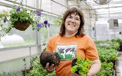 Theresa Freund holds plants growing in CowPots, a product made on the farm, in the Freund’s Farm Market & Bakery’s greenhouse. (Courtesy Cabot Creamery) Theresa Freund holds plants growing in CowPots, a product made on the farm, in the Freund’s Farm Market & Bakery’s greenhouse. (Courtesy Cabot Creamery)
