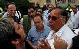 Haifa Mayor Yona Yahav (in white shirt), argues with a man in the city's Kiryat Eliezer neighborhood. (Phil Sussman /Flash90)