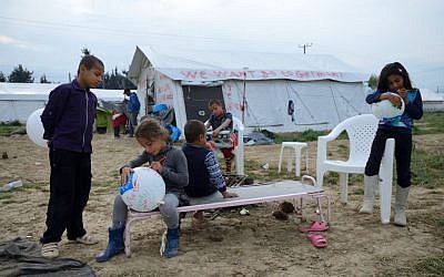 Refugee children playing near a tent painted with the slogan "We want go to Germany" in Idomeni refugee camp on May 1'st, 2016 (Photo Credit: Gili Yaari / Flash90)