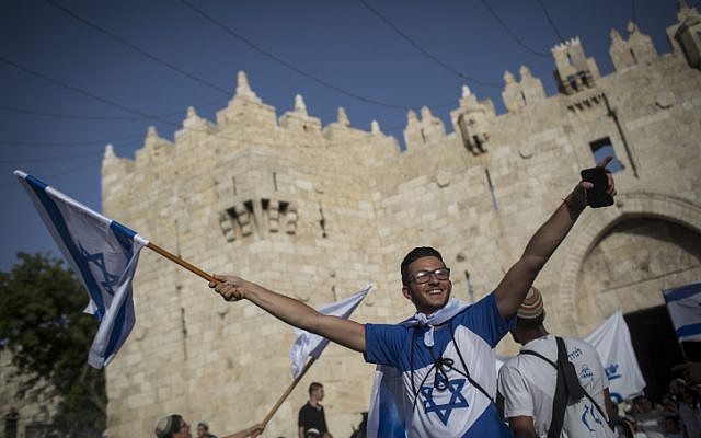 Thousands of mostly young, Jewish teenagers wave Israeli flags as they march through the Damascus Gate and into the Muslim Quarter on their way to the Western Wall to celebrate Jerusalem Day on June 05, 2016. (Hadas Parush/Flash90)