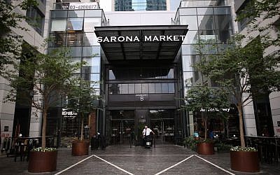 A security guard stands at an entrance to the Sarona Market shopping center in Tel Aviv, on June 9, 2016, the morning after a fatal terror attack took place there. (Miriam Alster/Flash90)