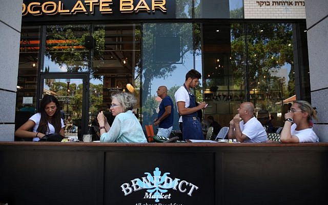 Israelis seen eating at Benedict restaurant at Sarona Market shopping center in Tel Aviv, on June 9, 2016, the morning after a fatal terror attack took place there. (Miriam Alster/Flash90)