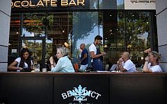 Israelis seen eating at Benedict's restaurant at the Sarona Market shopping center in central Tel Aviv, June 9, 2016, the morning after a deadly terror attack at the site. (Miriam Alster/Flash90)