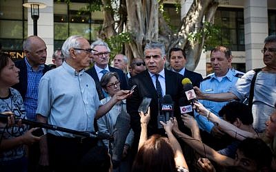 Leader of the Yesh Atid party Yair Lapid speaks to the press, along with foreign diplomats, after visiting the Max Brenner restaurant, the site of a June 8, 2016, terror attack, at Sarona Market, Tel Aviv, on June 10, 2016. (Miriam Alster/Flash90)