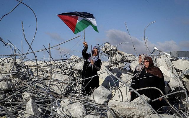 The mother of Palestinian terrorist Murad Idais holds a Palestinian flag as she stands in the rubble of their house after it was demolished by the IDF in the West Bank village of Yatta, south of Hebron, on June 11, 2016. Idais stabbed mother-of-six Dafna Meir to death. (Wisam Hashlamoun/Flash90) The mother of Palestinian terrorist Murad Idais holds a Palestinian flag as she stands in the rubble of their house after it was demolished by the IDF in the West Bank village of Yatta, south of Hebron, on June 11, 2016. Idais stabbed mother-of-six Dafna Meir to death. (Wisam Hashlamoun/Flash90)