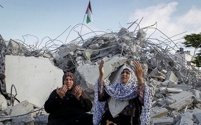 Family members of Palestinian terrorist Morad Adais are seen in the rubble of their house after it was demolished by Israeli forces in the West Bank village of Yatta, south of Hebron, on June 11, 2016 (Wisam Hashlamoun/Flash90)