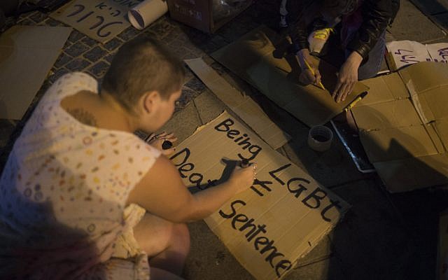 Young Israeli LGBT activists write signs as they gather at Zion Square in Jerusalem in solidarity with the victims of the shooting attack at a gay club in Orlando, USA, on June 12, 2016. (Hadas Parush/Flash90)