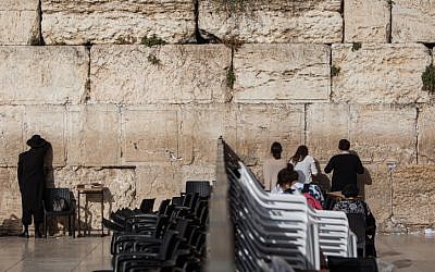 People pray on either side of the dividing wall that separates the male and female prayer sections at the Western Wall, June 14, 2016. (Wajsgras/Flash90)
