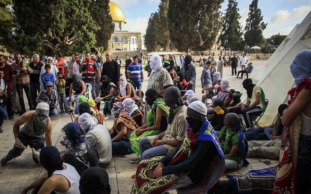 Masked Palestinians hold stones as they gesture during clashes with Israeli police during the holy month of Ramadan near Al-Aqsa Mosque on the Temple Mount in Jerusalem's Old City June 28, 2016. (Muammar Awad/Flash90)