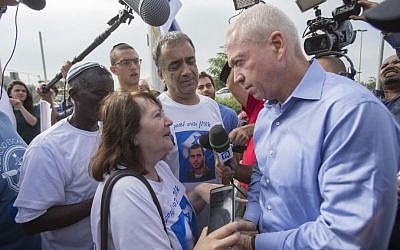Housing Minister Yoav Galant speaks with the parents of Avraham Mengistu and parents of late IDF soldier Oron Shaul outside the Prime Minister's Office, during a protest against the agreement with Turkey in Jerusalem, June 29, 2016. (Yonatan Sindel/Flash90) 