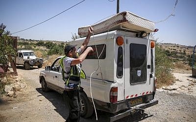 A volunteer loads a bloodied mattress from the bedroom of Hallel Yaffa Ariel, killed in a stabbing attack in her Kiryat Arba home, on June 30, 2016. (Hadas Parush/Flash90)