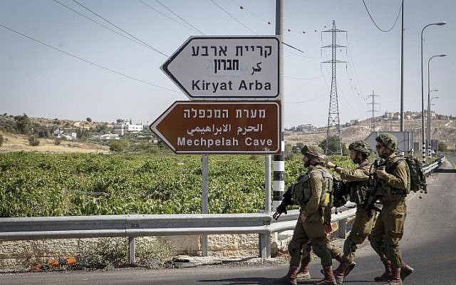 Israeli soldiers patrol the area around the entrance to the Kiryat Arba settlement in the West Bank on June 30, 2016, after a Palestinian teenager stabbed and killed a 13-year-old Israeli girl there. (Wisam Hashlamoun/Flash90)