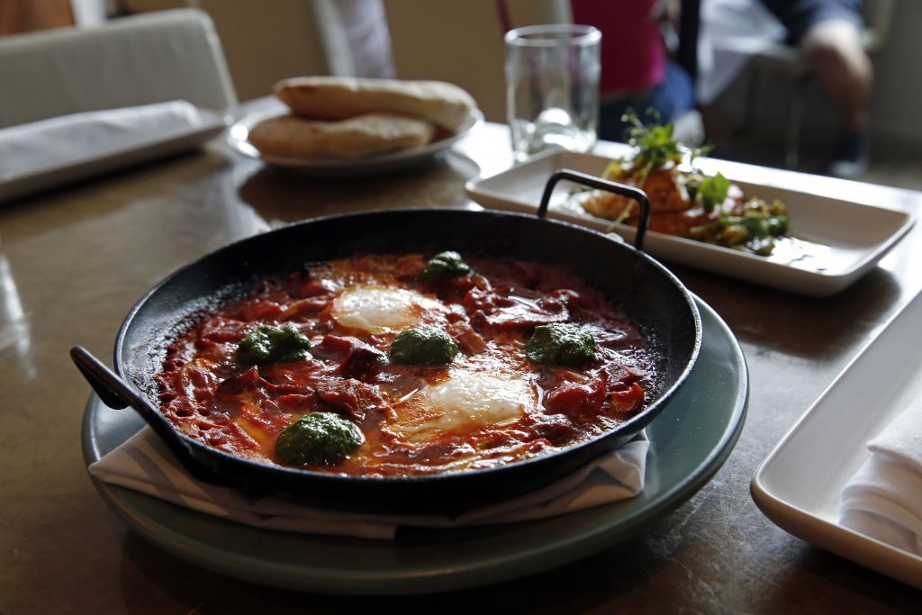 In this May 31, 2016 photo, Shakshouka, which is chermoula, Jerusalem artichokes, spicy chilies, tomato and egg, sits on a table at Shaya Restaurant, in New Orleans. (AP Photo/Gerald Herbert) In this May 31, 2016 photo, Shakshouka, which is chermoula, Jerusalem artichokes, spicy chilies, tomato and egg, sits on a table at Shaya Restaurant, in New Orleans. (AP Photo/Gerald Herbert)