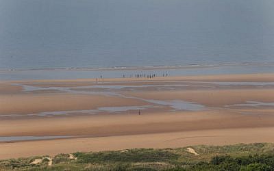 WWII enthusiasts from Spain wearing 101st Airbone gears walk on Omaha beach next to the Colleville American military cemetery, in Colleville sur Mer, western France, June 5, 2016. (AP Photo/Francois Mori)