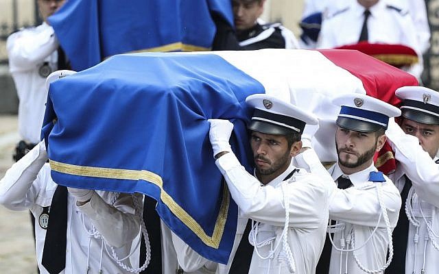 Police officers carry the coffins of the two police officials killed by an extremist claiming allegiance to IS, during a ceremony, Friday June 17, 2016 in Versailles, near Paris. (AP Photo/Kamil Zihnioglu)