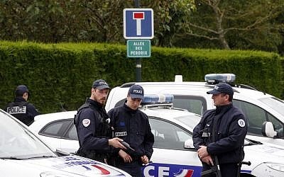 French police officers block the road leading to a crime scene the day after a knife-wielding attacker stabbed a senior police officer to death Monday evening outside his home in Magnanville, west of Paris, France, Tuesday, June 14, 2016. (AP Photo/Thibault Camus)