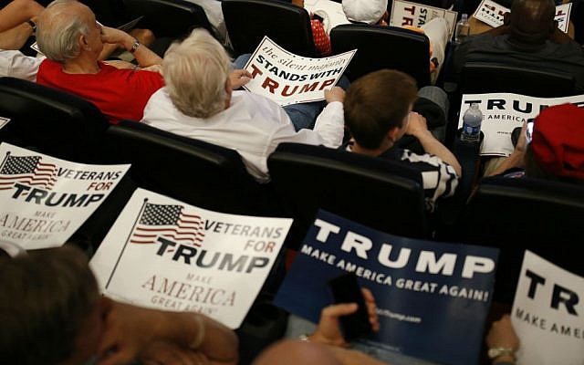 People hold signs as they wait for Republican presidential candidate Donald Trump to speak at the Treasure Island hotel and casino, Saturday, June 18, 2016, in Las Vegas, Nevada. (AP Photo/John Locher)