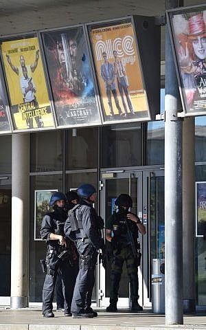 Police officers stand in front of a cinema in Viernheim near Mannheim, southern Germany, Thursday, June 23, 2016, where a gunman was shot after he took hostages in the complex (Boris Roessler/dpa via AP)