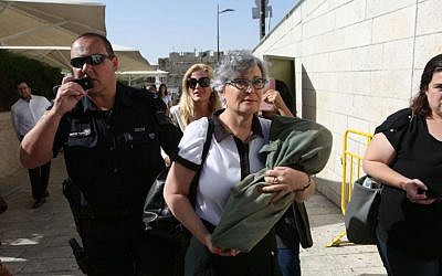 Women of the Wall Executive Director Leslie Sachs carrying a Torah scroll as she is escorted away from the Western Wall plaza by police, June 7, 2016. (Michal Fattal)