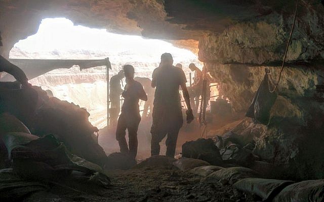 Volunteers and archaeologists working in the Cave of the Skulls, overlooking Nahal Tze'elim in the Judean Desert on June 1, 2016. (Ilan Ben Zion/Times of Israel staff)