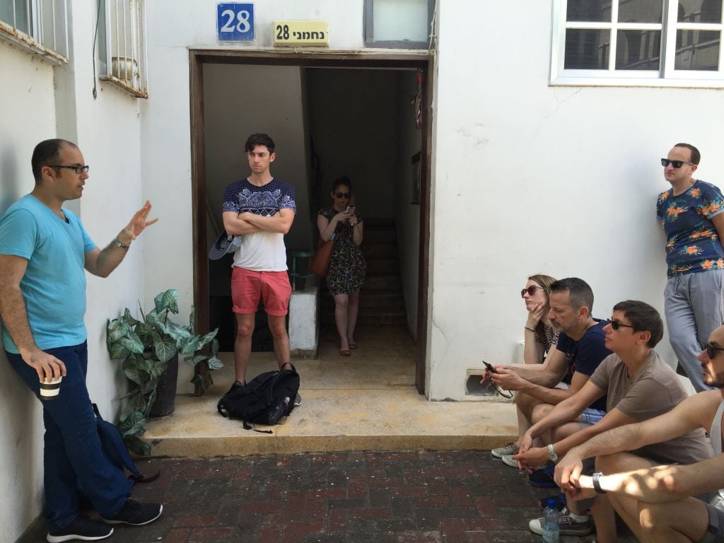 LGBT activist Shai Doitsh speaking to visiting journalists on June 1, 2106 at 28 Nachmani Street, the first home of Aguda, the LGBT taskforce (Jessica Steinberg/Times of Israel)