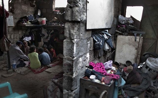 In this Monday, June 20, 2016 photo, a Palestinian family breaks their Ramadan fast in their house in el-Zohor slum, on the outskirts of Khan Younis refugee camp, southern Gaza Strip. (AP Photo/ Khalil Hamra)