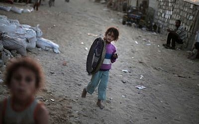 A Palestinian girl walks barefoot in el-Zohor slum, on the outskirts of Khan Younis refugee camp, southern Gaza Strip, June 20, 2016. (AP Photo/Khalil Hamra)