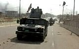 A still image from video of Iraqi troops carrying Iraqi flags on their vehicles after a senior Iraqi commander declared that the city of Fallujah was "fully liberated" from Islamic State group militants, in Fallujah, Iraq, June 26, 2016. (AP Video via AP)